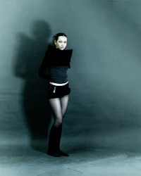 a woman wearing black shorts and a black sweater