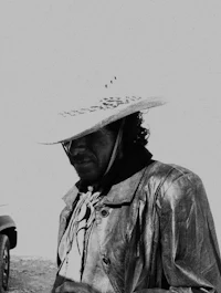 a man in a cowboy hat standing next to a truck