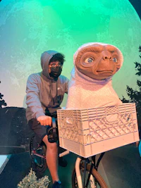 a man riding a bicycle with a sloth doll