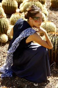 a woman kneeling in front of cactus plants
