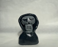 a figurine of a skeleton wearing a hood