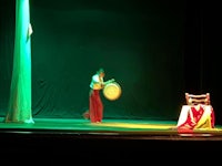 a man is playing a drum on stage