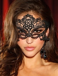 a woman wearing a black lace masquerade mask