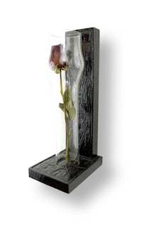 a glass vase with a rose in it
