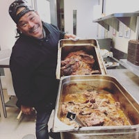 a man holding a tray of meat