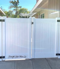 a white gate with a black handle on it