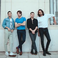 a group of men leaning against a wall