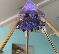 a pyramid made of glass and metal with a light in the middle