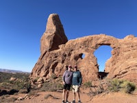 two men standing in front of a rock formation