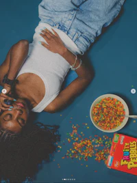 a woman laying on the floor with a bowl of cereal