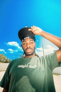 a man wearing a green t - shirt and hat
