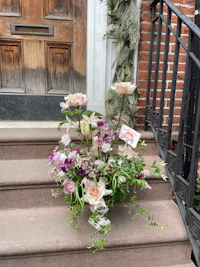 a flower arrangement on the steps of a house