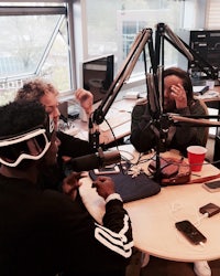 a group of people sitting around a table with microphones