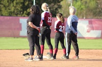 a group of softball players standing on a field