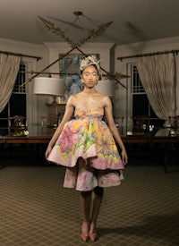 a woman in a floral dress standing in a room