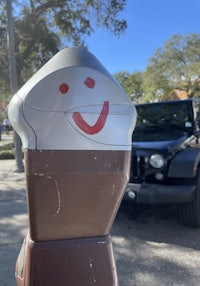 a parking meter with a smiley face on it