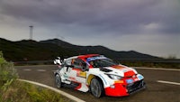 a rally car driving down a mountain road