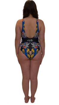 the back view of a woman in a black and blue floral one piece swimsuit