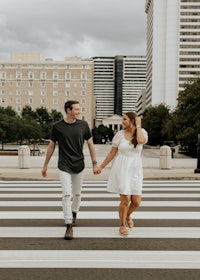 an engaged couple walking across a crosswalk in downtown atlanta