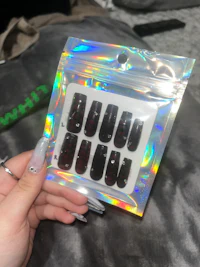 a person holding a package of holographic nails