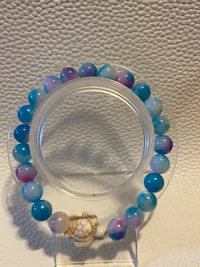 a bracelet with blue and purple beads and a turtle charm