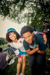 two people posing for a photo in a park
