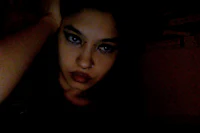 a girl in a dark room posing for a picture