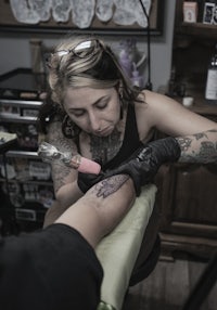 a woman getting a tattoo at a tattoo shop