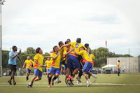 a group of people playing a game of frisbee on a soccer field