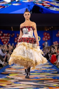 a woman wearing a mickey mouse dress on the runway