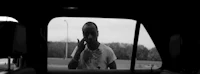 a black and white photo of a man in a car