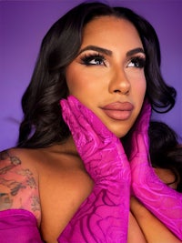 a woman in purple gloves posing on a purple background