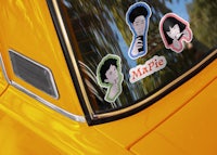 a yellow car with stickers on the window