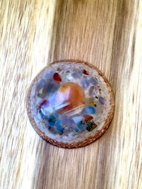 a colorful glass pendant on a wooden table