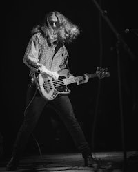 a black and white photo of a man playing a bass