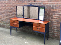 a blue and white dressing table with a mirror
