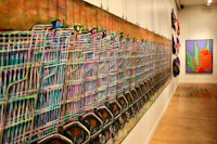 a line of paintings on a wall in an art gallery