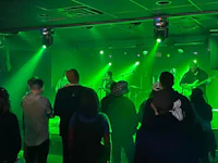 a group of people standing in a room with green lights