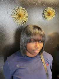 a woman in a blue shirt standing in front of a wall