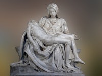 a statue of jesus laying on the ground