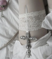 a woman's legs with a lace garter and a sword