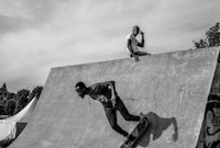 a black and white photo of a skateboarder on a ramp