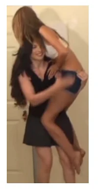 a woman is holding a woman's leg in a bathroom