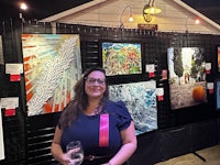 a woman standing in front of a display of art