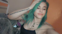 a girl with green hair posing in a room