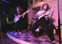 a group of people playing guitars in a dark room