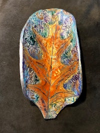 a plate with a colorful leaf on it