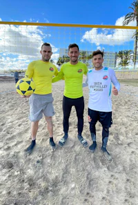 three men posing for a photo on the beach
