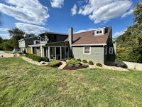 a home with a green lawn and trees