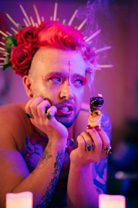a man with red hair is eating a donut